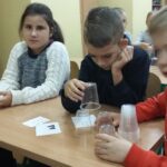 Uczniowie przy szkolnej ławce podczas lekcji
